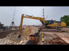 Excavator lengan panjang dengan ember pengunggahan untuk pengunggahan di dermaga